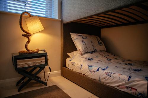 a bedroom with a bed and a lamp on a night stand at Sennen Cove Cottage in Sennen Cove