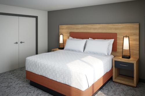 a bedroom with a large bed and two lamps at Candlewood Suites - Columbia by IHG in Columbia