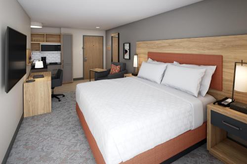 a bedroom with a large white bed and a desk at Candlewood Suites - Columbia by IHG in Columbia
