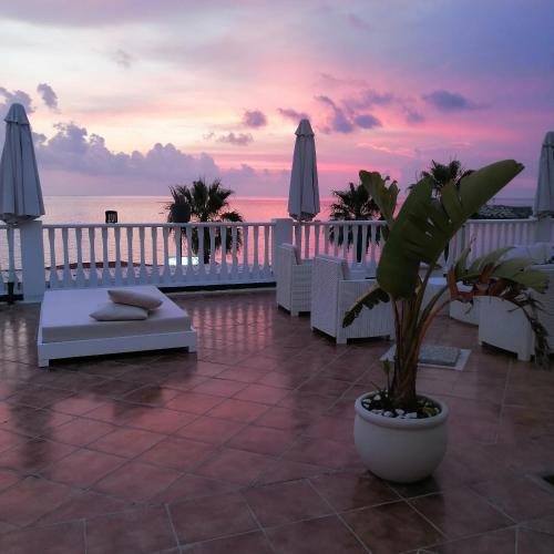 a resort patio with a table and chairs and the ocean at Eneide in Palmi