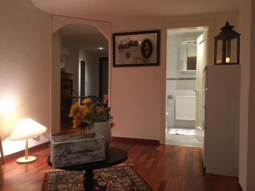 a living room with a table and a mirror at Charmante maison VintageCorner in Saint-Blaise