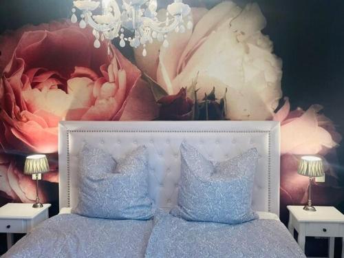 - une chambre avec un lit orné d'une peinture florale sur le mur dans l'établissement Apartment in Meersburg right on the water, à Meersburg