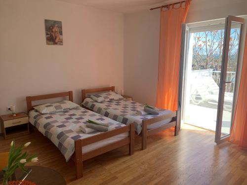 a bedroom with two beds and a sliding glass door at Apartmaji Amitis in Portorož