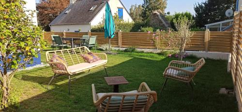 un patio trasero con 2 sillas y un sofá en el césped en Ty Calouenn, la plage à pied en Le Pouldu