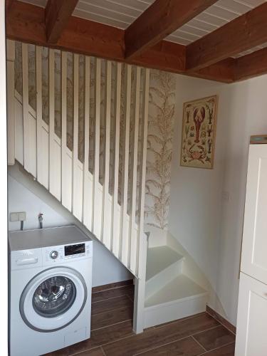 a laundry room with a washer and a staircase at Ty Calouenn, la plage à pied in Le Pouldu