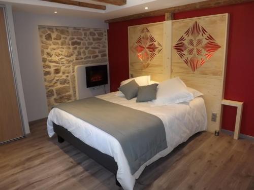ein Schlafzimmer mit einem großen Bett und einer Steinmauer in der Unterkunft La maison de gilbert in Chaudes-Aigues