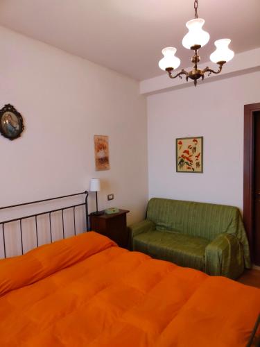 - une chambre avec un lit orange et une chaise dans l'établissement I Duchi Pellegrini, à Santa Maria Nuova