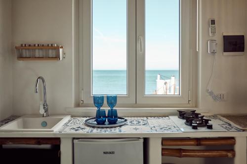 una cucina con due bicchieri su un bancone con finestra di Sea view life a Carini