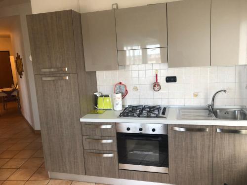 a kitchen with a stove and a sink at Apartment Verdiano in Parma