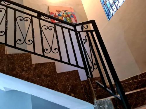 a staircase with wrought iron railings and marble steps at Cozy Quiet & Fantastic- Close to Highway - Parking in Apenkwa