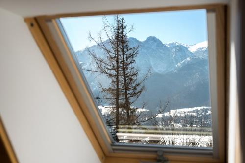 a window with a view of a snow covered mountain at Osada Gubałówka na Polanie Pająkówka & SPA in Kościelisko