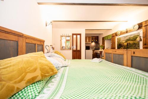 a bedroom with a bed with a green and yellow comforter at Apartmány Tollendorf Lužické hory in Jiřetín pod Jedlovou