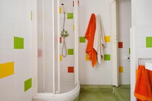 Łazienka z prysznicem wyłożona jest pomarańczowymi i zielonymi kafelkami. w obiekcie Nisia B&B w Barcelonie