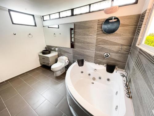 Un baño con bañera blanca y un inodoro. en Villa Principessa - Lujo y comfort, en La Tebaida