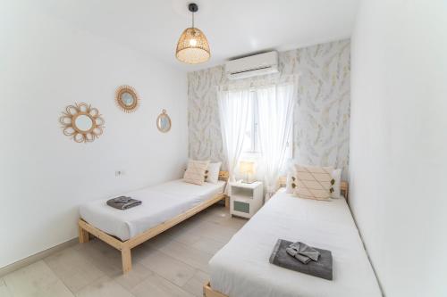 Un dormitorio con dos camas y una ventana en Villa Alba, en Playa Blanca