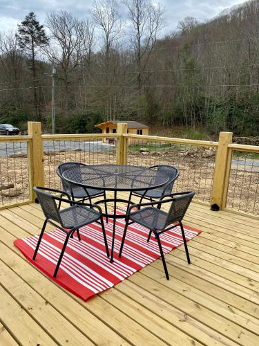 a patio table and two chairs on a deck at Maggie Valley Cabin Rentals in Maggie Valley