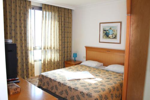a hotel room with a bed and a window at Studios By The Sea in Haifa