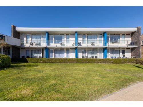 un immeuble d'appartements avec une pelouse devant lui dans l'établissement Beautiful Apartment in Zoutelande with Terrace, à Zoutelande