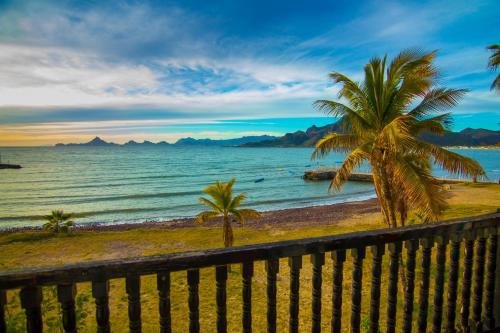 a beach with two palm trees and the ocean at Hotel Playa de Cortes in Guaymas
