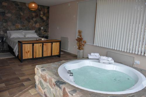 a large bath tub in a room with a bed at Potre casas de montaña in Potrerillos