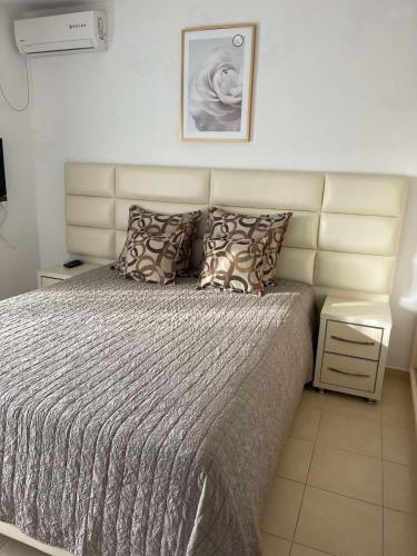 a bedroom with a large bed with a headboard at ApartsDobraVoda in Dobra Voda