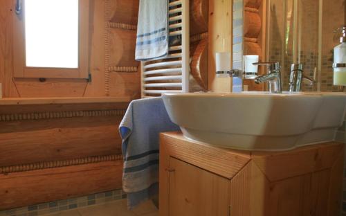ein Bad mit einem weißen Waschbecken und einem Fenster in der Unterkunft Domek na Skałce in Żabnica