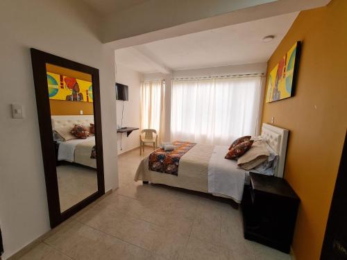 a bedroom with a bed and a large mirror at Hotel San Blass in La Unión