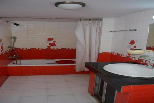 a red bathroom with a tub and a sink at Hotel Rose Garden in Chittagong