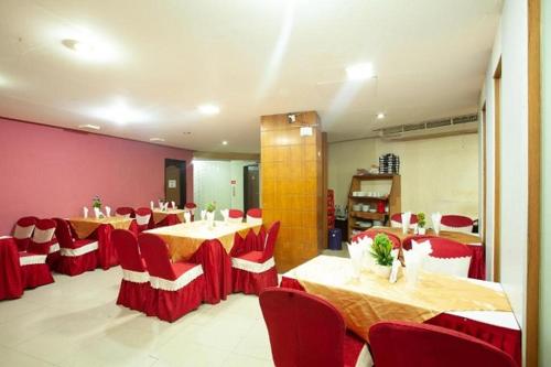 a dining room with tables and red chairs at Hotel Rose Garden in Chittagong
