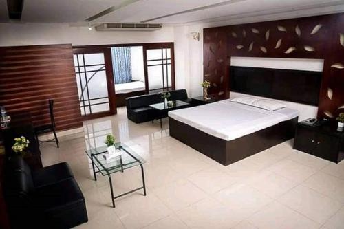 1 dormitorio con cama, sofá y mesa en Hotel Rose Garden en Chittagong