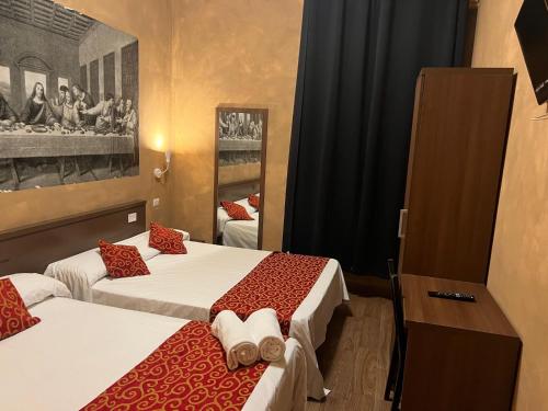 a hotel room with two beds and a mirror at Albergo Corvetto Corso Lodi in Milan