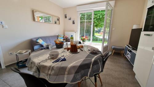 ein Wohnzimmer mit einem Tisch und einem Sofa in der Unterkunft Appartement Capsea 4 étoiles, St Valery-sur-S, avec 2 parkings gratuits in Saint-Valery-sur-Somme