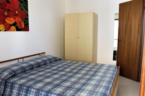 1 dormitorio con 1 cama y armario en Appartamenti Elena, en Grado