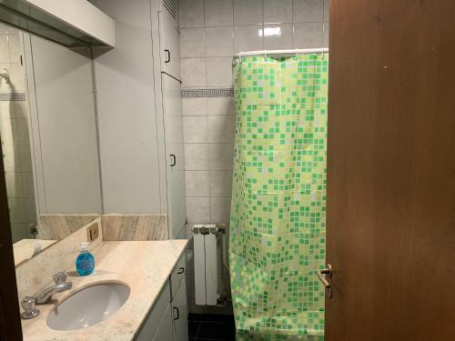 a bathroom with a green shower with a sink at Hostel la Embajada in Mendoza