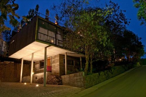 Una casa se ilumina por la noche con luces en Hotel Casa Zapallar, en Zapallar