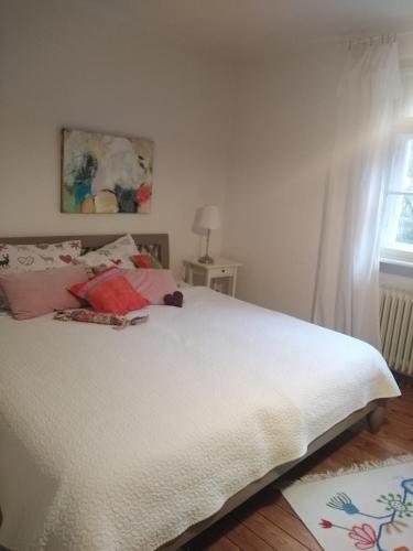 a bedroom with a large white bed with a window at Haus Pfaffenfels in Schönau