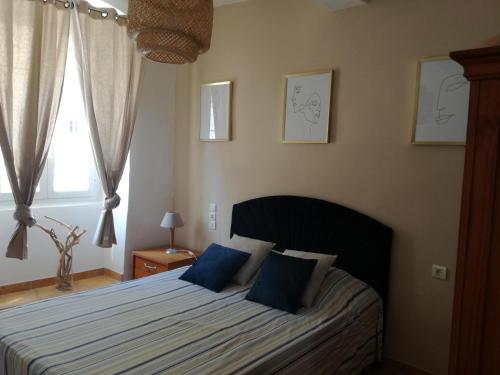 Un dormitorio con una cama con almohadas azules y una ventana en Bella vista, en Bastia