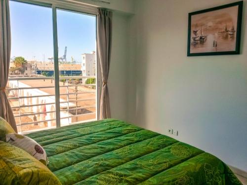 ein Schlafzimmer mit einem Bett und einem großen Fenster in der Unterkunft Blume Apartment Casa Port - 2 Bedrooms in Casablanca
