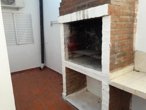 a brick fireplace with a chair inside of it at Dptos Astrada in Goya