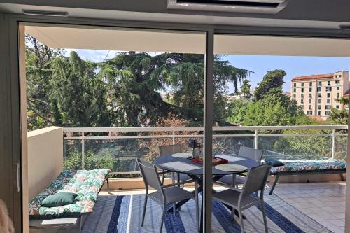 un balcon avec une table et des chaises et une vue dans l'établissement HENRI CAMILLE REAL ESTATE -Beautiful one bedroom swimming pool and parking, à Cannes