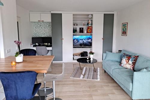 un salon avec un canapé bleu et une table dans l'établissement HENRI CAMILLE REAL ESTATE -Beautiful one bedroom swimming pool and parking, à Cannes