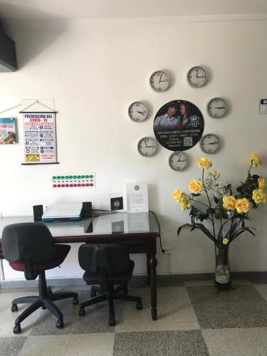 an office with a desk and clocks on the wall at Casa Villavicencio in Villavicencio