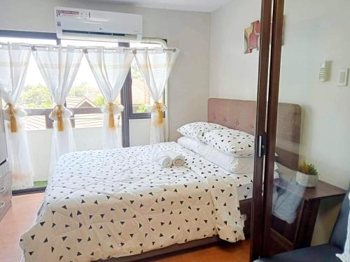 ein kleines Schlafzimmer mit einem Bett und einem Fenster in der Unterkunft One Oasis by Paseo de Corazon Residence in Cagayan de Oro