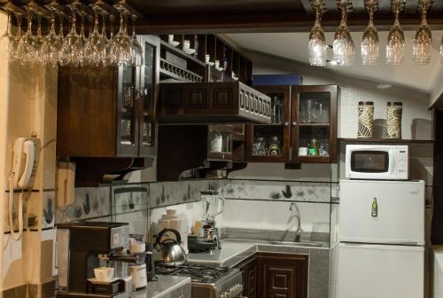 uma cozinha com armários de madeira e um frigorífico branco em Cusco Bed and Breakfast em Cusco