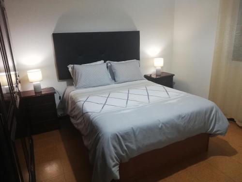a bedroom with a large bed with two lamps at House Joel & Sonia with sea view in Funchal