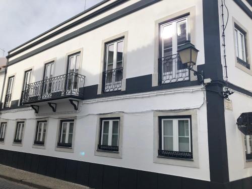 a white building with balconies on a street at Pátio da Villa - Coruche Boutique Guest House in Coruche