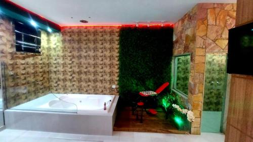 a bathroom with a tub and a green wall at MOTEL COPACABANA in Ribeirão Preto