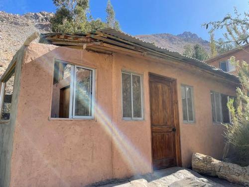 a small pink house with a door and windows at Cabañas Luna de Cuarzo, Cochiguaz in Paihuano