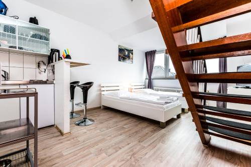 ケルンにあるBudget Apartment Kölnのベッドと階段が備わる小さな客室です。