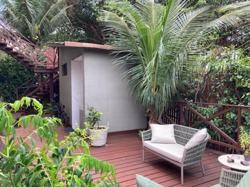 a patio with a chair on a wooden deck at Flats Baia dos Porcos in Fernando de Noronha